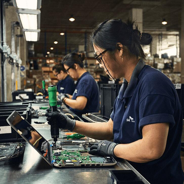 SK Tes employee pulling spare parts from laptop - e waste recycling